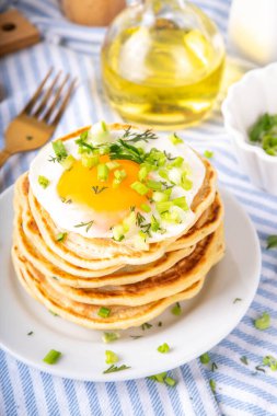 Lezzetli kahvaltı krepleri, taze soğan ve kızarmış yumurta. Lezzetli ya da tatlı olmayan krepleri beyaz mutfak masasında maydanozlu ve güneşli yumurtalarla fotokopi masasının üzerinde.