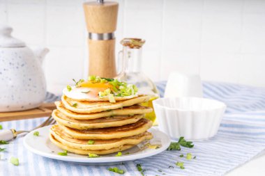 Lezzetli kahvaltı krepleri, taze soğan ve kızarmış yumurta. Lezzetli ya da tatlı olmayan krepleri beyaz mutfak masasında maydanozlu ve güneşli yumurtalarla fotokopi masasının üzerinde.