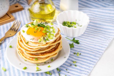 Lezzetli kahvaltı krepleri, taze soğan ve kızarmış yumurta. Lezzetli ya da tatlı olmayan krepleri beyaz mutfak masasında maydanozlu ve güneşli yumurtalarla fotokopi masasının üzerinde.