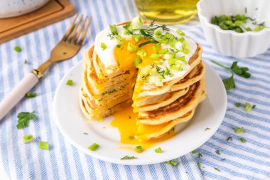 Lezzetli kahvaltı krepleri, taze soğan ve kızarmış yumurta. Lezzetli ya da tatlı olmayan krepleri beyaz mutfak masasında maydanozlu ve güneşli yumurtalarla fotokopi masasının üzerinde.