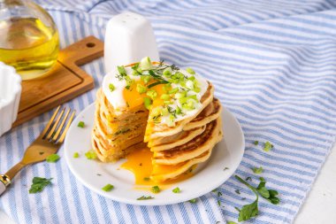 Lezzetli kahvaltı krepleri, taze soğan ve kızarmış yumurta. Lezzetli ya da tatlı olmayan krepleri beyaz mutfak masasında maydanozlu ve güneşli yumurtalarla fotokopi masasının üzerinde.