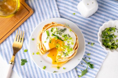 Lezzetli kahvaltı krepleri, taze soğan ve kızarmış yumurta. Lezzetli ya da tatlı olmayan krepleri beyaz mutfak masasında maydanozlu ve güneşli yumurtalarla fotokopi masasının üzerinde.