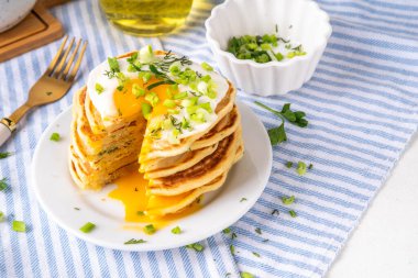 Lezzetli kahvaltı krepleri, taze soğan ve kızarmış yumurta. Lezzetli ya da tatlı olmayan krepleri beyaz mutfak masasında maydanozlu ve güneşli yumurtalarla fotokopi masasının üzerinde.
