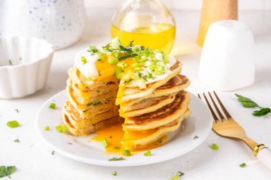 Lezzetli kahvaltı krepleri, taze soğan ve kızarmış yumurta. Lezzetli ya da tatlı olmayan krepleri beyaz mutfak masasında maydanozlu ve güneşli yumurtalarla fotokopi masasının üzerinde.