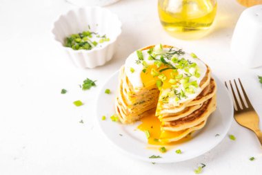Lezzetli kahvaltı krepleri, taze soğan ve kızarmış yumurta. Lezzetli ya da tatlı olmayan krepleri beyaz mutfak masasında maydanozlu ve güneşli yumurtalarla fotokopi masasının üzerinde.