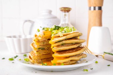 Lezzetli kahvaltı krepleri, taze soğan ve kızarmış yumurta. Lezzetli ya da tatlı olmayan krepleri beyaz mutfak masasında maydanozlu ve güneşli yumurtalarla fotokopi masasının üzerinde.