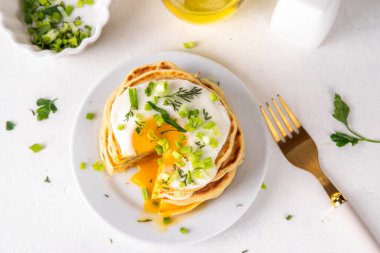 Lezzetli kahvaltı krepleri, taze soğan ve kızarmış yumurta. Lezzetli ya da tatlı olmayan krepleri beyaz mutfak masasında maydanozlu ve güneşli yumurtalarla fotokopi masasının üzerinde.