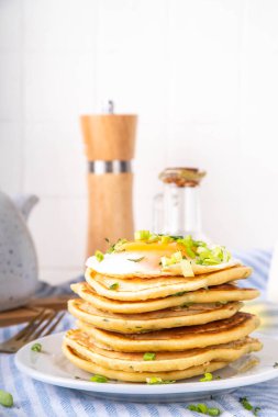 Lezzetli kahvaltı krepleri, taze soğan ve kızarmış yumurta. Lezzetli ya da tatlı olmayan krepleri beyaz mutfak masasında maydanozlu ve güneşli yumurtalarla fotokopi masasının üzerinde.