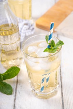 Soğuk vanilyalı soda. Sıcak yaz günleri için, beyaz ahşap masa fotokopisinde bol miktarda ezilmiş buz ve nane aromalı alkolsüz içecek.