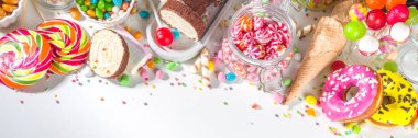 Renkli şekerlerden seç. Çeşitli şeker setleri, çikolatalar, çörekler, kurabiyeler, lolipoplar, beyaz arka planda dondurma üst görünümü