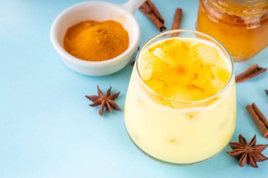 Buzlu altın sütlü içecek, buz küplü zerdeçal latte, yaz mevsimi soğuk içeceği, alternatif ayurvedic kokteyl.