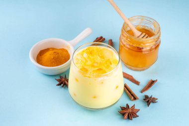 Buzlu altın sütlü içecek, buz küplü zerdeçal latte, yaz mevsimi soğuk içeceği, alternatif ayurvedic kokteyl.