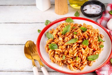 Bolonez soslu Fusilli makarna, kıyma, mantar, domates ve fesleğen. Geleneksel İtalyan yemek tabağı, masada servis edilen baharatlar.