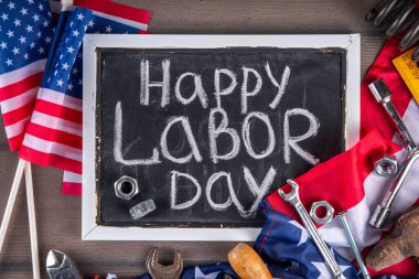 Amerikan Ulusal Vatansever İşçiler Mutlu İşçi Bayramı tatili geçmişi. Ahşap zemin üzerinde yıldızlı inşaat ve imalat araçları, kırmızı beyaz mavi çizgili Amerikan bayrağı