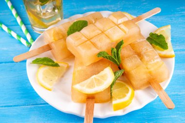 Buzlu çay veya limonata, tatlı limon ve naneli kokteyl lolipopları soğuk içecek, limon dilimleri ve nane yaprakları fotokopi alanı