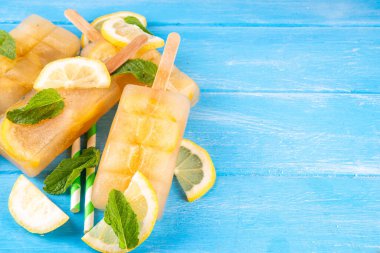 Buzlu çay veya limonata, tatlı limon ve naneli kokteyl lolipopları soğuk içecek, limon dilimleri ve nane yaprakları fotokopi alanı