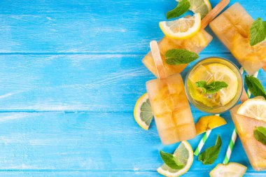 Buzlu çay veya limonata, tatlı limon ve naneli kokteyl lolipopları soğuk içecek, limon dilimleri ve nane yaprakları fotokopi alanı
