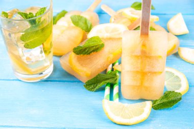 Buzlu çay veya limonata, tatlı limon ve naneli kokteyl lolipopları soğuk içecek, limon dilimleri ve nane yaprakları fotokopi alanı
