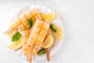 Buzlu çay veya limonata, tatlı limon ve naneli kokteyl lolipopları soğuk içecek, limon dilimleri ve nane yaprakları fotokopi alanı