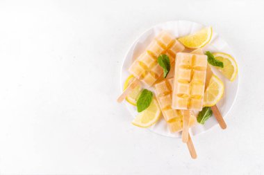 Buzlu çay veya limonata, tatlı limon ve naneli kokteyl lolipopları soğuk içecek, limon dilimleri ve nane yaprakları fotokopi alanı
