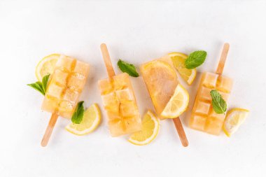 Buzlu çay veya limonata, tatlı limon ve naneli kokteyl lolipopları soğuk içecek, limon dilimleri ve nane yaprakları fotokopi alanı