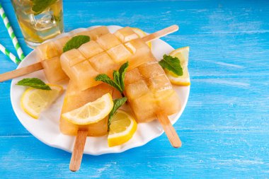 Buzlu çay veya limonata, tatlı limon ve naneli kokteyl lolipopları soğuk içecek, limon dilimleri ve nane yaprakları fotokopi alanı