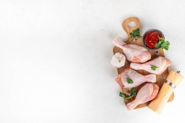 Tavuk eti hazırlama arka planı, ızgaraya hazır çiğ tavuk bacağı, baharatlar, tuz, biber, zeytinyağı, sarımsak ve salamura veya sos. Izgara ve bbq sezon pişirme arka planı, kopyalama alanı