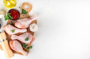 Tavuk eti hazırlama arka planı, ızgaraya hazır çiğ tavuk bacağı, baharatlar, tuz, biber, zeytinyağı, sarımsak ve salamura veya sos. Izgara ve bbq sezon pişirme arka planı, kopyalama alanı