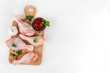 Tavuk eti hazırlama arka planı, ızgaraya hazır çiğ tavuk bacağı, baharatlar, tuz, biber, zeytinyağı, sarımsak ve salamura veya sos. Izgara ve bbq sezon pişirme arka planı, kopyalama alanı