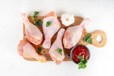 Tavuk eti hazırlama arka planı, ızgaraya hazır çiğ tavuk bacağı, baharatlar, tuz, biber, zeytinyağı, sarımsak ve salamura veya sos. Izgara ve bbq sezon pişirme arka planı, kopyalama alanı