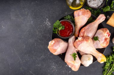 Tavuk eti hazırlama arka planı, ızgaraya hazır çiğ tavuk bacağı, baharatlar, tuz, biber, zeytinyağı, sarımsak ve salamura veya sos. Izgara ve bbq sezon pişirme arka planı, kopyalama alanı