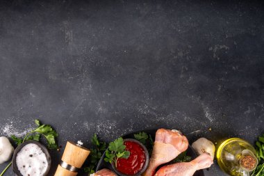 Tavuk eti hazırlama arka planı, ızgaraya hazır çiğ tavuk bacağı, baharatlar, tuz, biber, zeytinyağı, sarımsak ve salamura veya sos. Izgara ve bbq sezon pişirme arka planı, kopyalama alanı