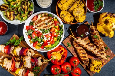 Izgara yaz bbq tabakları. Barda piknik pikniği çeşitli ızgara yiyeceklerle - şiş kebap şiş şiş, ızgara mısır, kızarmış tavuk salata, biftek, sosis, sebze