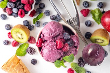 Ev yapımı meyve ve meyveli dondurma, sağlıklı meyve ve yoğurt ile porsiyonlu dondurma taze yaban mersini, ahududu, çilek, böğürtlen, elmalar, mutfak masasında kivi.