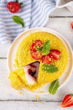 Tepetaklak Pasta yok, klasik Cheesecake New York 'un viral modası altın kurabiye parçacıkları, beyaz krem peynir ve böğürtlen reçeli katmanları, taze çilek ve ahşap masa üzerinde nane