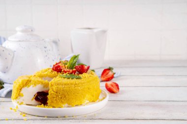 Tepetaklak Pasta yok, klasik Cheesecake New York 'un viral modası altın kurabiye parçacıkları, beyaz krem peynir ve böğürtlen reçeli katmanları, taze çilek ve ahşap masa üzerinde nane