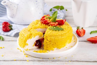 Tepetaklak Pasta yok, klasik Cheesecake New York 'un viral modası altın kurabiye parçacıkları, beyaz krem peynir ve böğürtlen reçeli katmanları, taze çilek ve ahşap masa üzerinde nane