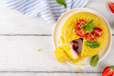 Tepetaklak Pasta yok, klasik Cheesecake New York 'un viral modası altın kurabiye parçacıkları, beyaz krem peynir ve böğürtlen reçeli katmanları, taze çilek ve ahşap masa üzerinde nane