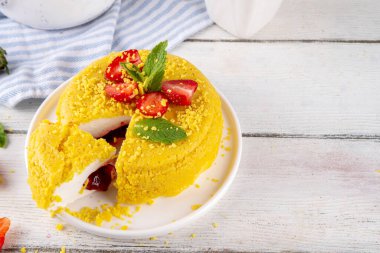 Tepetaklak Pasta yok, klasik Cheesecake New York 'un viral modası altın kurabiye parçacıkları, beyaz krem peynir ve böğürtlen reçeli katmanları, taze çilek ve ahşap masa üzerinde nane