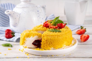 Tepetaklak Pasta yok, klasik Cheesecake New York 'un viral modası altın kurabiye parçacıkları, beyaz krem peynir ve böğürtlen reçeli katmanları, taze çilek ve ahşap masa üzerinde nane