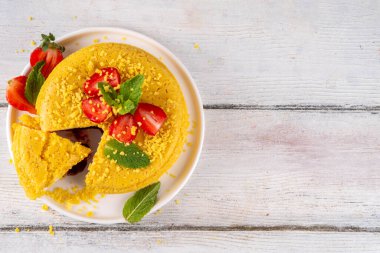 Tepetaklak Pasta yok, klasik Cheesecake New York 'un viral modası altın kurabiye parçacıkları, beyaz krem peynir ve böğürtlen reçeli katmanları, taze çilek ve ahşap masa üzerinde nane