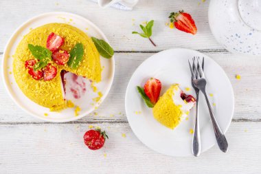 Tepetaklak Pasta yok, klasik Cheesecake New York 'un viral modası altın kurabiye parçacıkları, beyaz krem peynir ve böğürtlen reçeli katmanları, taze çilek ve ahşap masa üzerinde nane