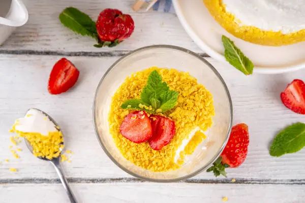 Klasik cam kaplı cheesecake, taze çilekli ve altın kurabiyeli. Katmanlı cheesecake tatlısıyla beyaz ahşap masa üzerinde taze çilekler fotokopi alanı