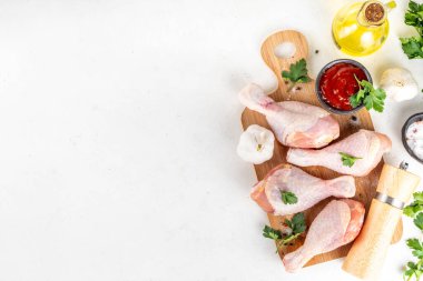 Tavuk eti hazırlama arka planı, ızgaraya hazır çiğ tavuk bacağı, baharatlar, tuz, biber, zeytinyağı, sarımsak ve salamura veya sos. Izgara ve bbq sezon pişirme arka planı, kopyalama alanı