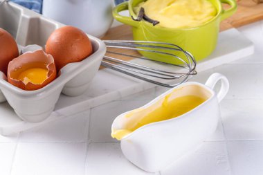 Malzemeli ev yapımı krema. Vanilya, süt ve yumurta. Tatlı krema beyaz mutfak masasının fotokopi masasında tatlı pişirme arkaplanı. 