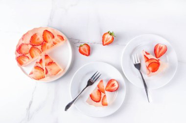 Japon yağmur damlası keki, ya da Mizu Shingen Mochi, berrak jöle tatlısı, kristal berrak su benzeri lezzetli, çilek dilimli tart, tabaklar üzerine porsiyonlu, beyaz mermer arka plan fotokopi alanı