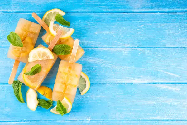 Buzlu çay veya limonata, tatlı limon ve naneli kokteyl lolipopları soğuk içecek, limon dilimleri ve nane yaprakları fotokopi alanı