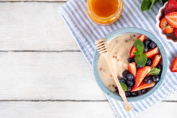 Kremalı buğday irmikli yulaf lapası ve taze yaz meyvesi. Kahvaltıda sütlü, çilekli, yaban mersinli ve ballı krema.