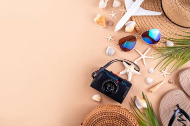 Yaz tatili ve hasır şapkalı, çantalı, terlikli, palmiye yapraklı, güneş gözlüklü, kameralı, deniz kabuklu ve okyanus yıldızlı tatil geçmişi. Plaj ve tropikal yaz tatili arka planı, üst görünüm kopyalama alanı