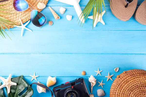 Yaz tatili ve hasır şapkalı, çantalı, terlikli, palmiye yapraklı, güneş gözlüklü, kameralı, deniz kabuklu ve okyanus yıldızlı tatil geçmişi. Plaj ve tropikal yaz tatili arka planı, üst görünüm kopyalama alanı